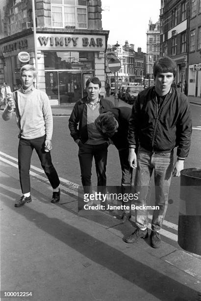 Portrait of British mod rock group Purple Hearts as they clown about in Soho, London, England, 1980. Pictured are, from left, bass player Jeff...