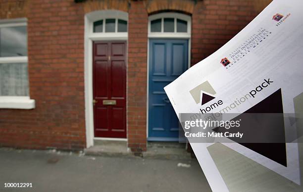 In this photo illustration a man looks at a home information pack outside properties on May 20, 2010 in Bath, England. The new coalition government...