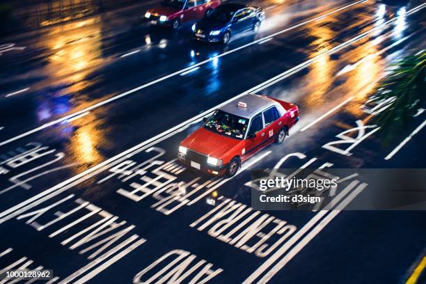 taxi driving in urban road on a rainy day at night - day for night 2017 fotografías e imágenes de stock