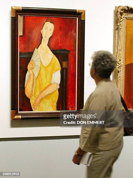 Photo taken on May 21, 2004 shows a visitor looking at the painting "La Femme à l'éventail" by Amedeo Modigliani during an exhibition at The Jewish...