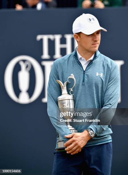 Jordan Spieth of the United States, winner of the 146th Open Championship, carries the Claret Jug onto the first tee as he returns it during previews...