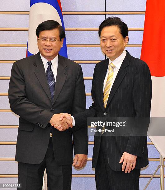 Laotian Prime Minister Bouasone Bouphavanh is welcomed by his Japanese counterpart Yukio Hatoyama at the latter's official residence in Tokyo on May...