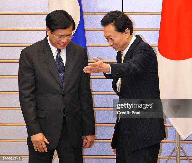 Laotian Prime Minister Bouasone Bouphavanh is welcomed by his Japanese counterpart Yukio Hatoyama at the latter's official residence in Tokyo on May...