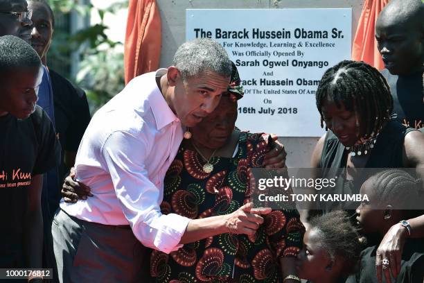 Former US President, Barack Obama with his step-grandmother Sarah and half-sister, Auma and some of the local youth are pictured on July 16, 2018...