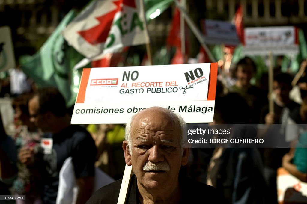 A demonstrator protests about cuts annou