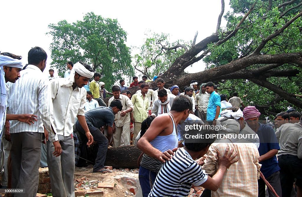 Indian people clear the debris at the si