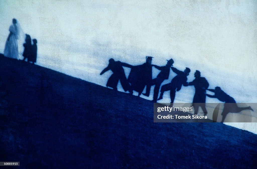 SILHOUETTE OF A BRIDE & PEOPLE WALKING UPHILL