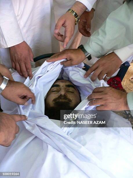 Relatives and followers of a Pakistani cleric Maulana Mirajuddin, take a last glimpse of his body during a funeral ceremony at Gomal village, near...