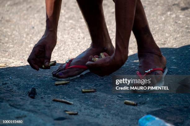 Resident of the Complex do Alemao favela collects cases on Itaoca Avenue as Rio de Janeiro's Military Police Special Unit carries out an operation at...
