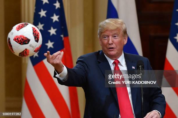 President Donald Trump throws to his wife a ball of the 2018 football World Cup that he received from Russia's President as a present during a joint...