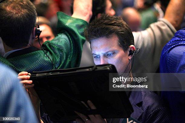 Trader Brad Hudson looks at his electronic tablet in the Eurodollar options trading pit at CME Group Inc.'s Chicago Board of Trade in Chicago,...