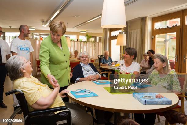 German Chancellor Angela Merkel speaks with elderly during a visit to the St. Johannesstift senior care facility on July 16, 2018 in Paderborn,...