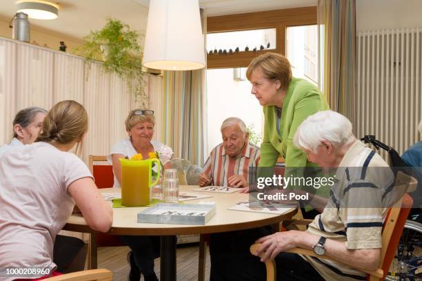 German Chancellor Angela Merkel speaks with residents during a visit to the St. Johannesstift senior care facility on July 16, 2018 in Paderborn,...