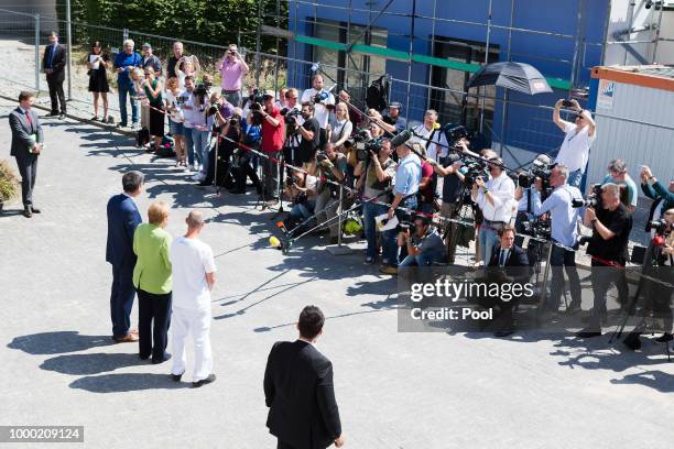 German Chancellor Angela Merkel poses with Ferdi Cebi , a caregiver at the St. Johannesstift senior care facility, during a visit on July 16, 2018 in...