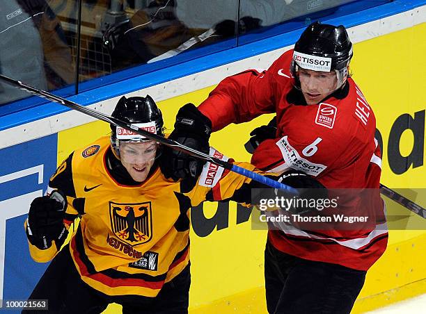 Alexander Barta of Germany battles for the puck with Timo Helbling of Switzerland during the IIHF World Championship quarter final match between...