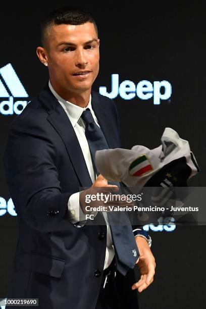 Juventus new signing Cristiano Ronaldo throws his new t-shirt as a present to the media during the press conference on July 16, 2018 in Turin, Italy.