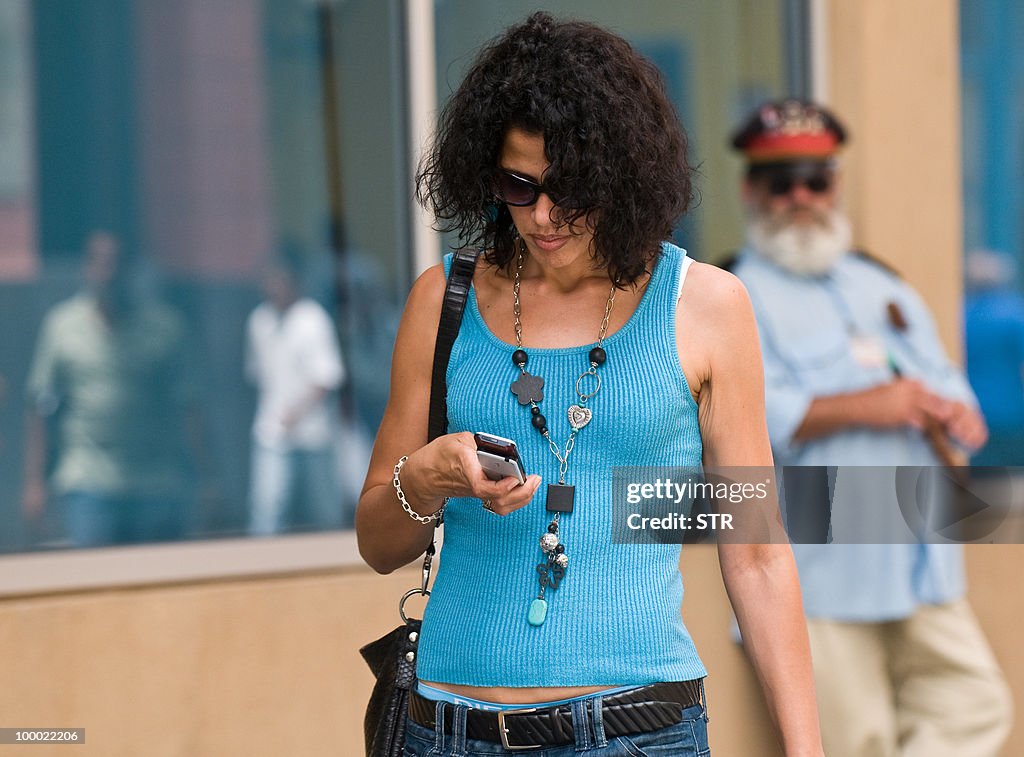 A Cuban woman uses her mobile phone in a