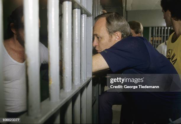 Coach Dale Brown leaning against prison bars at Louisiana State Penitentiary chatting with inmate on death row. Angola, LA 9/20/1985 CREDIT: George...