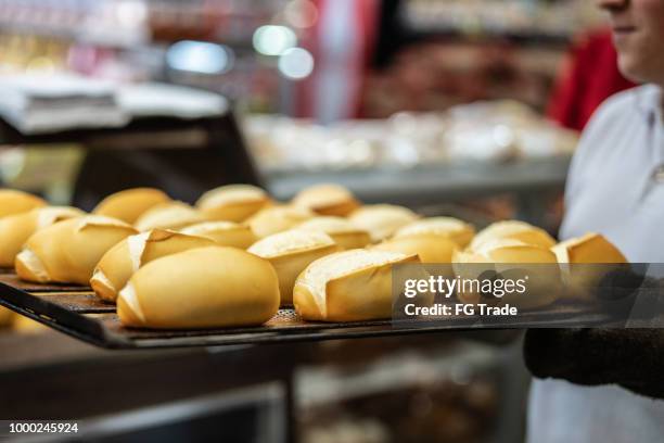 baker pulling a tray with hot bread - pão de leite imagens e fotografias de stock