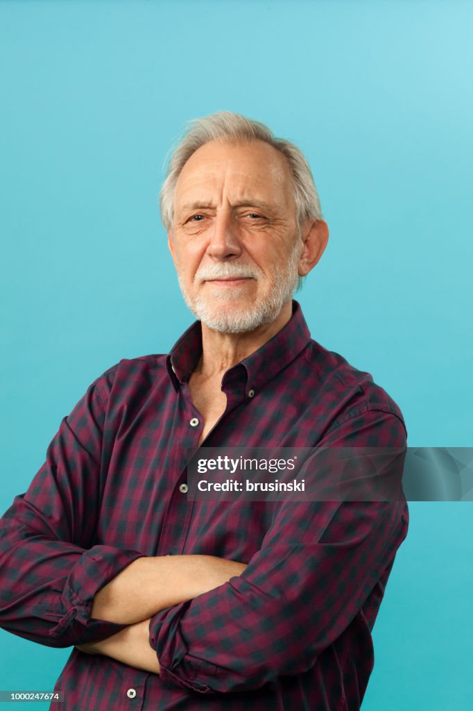 Close-up portrait of a senior men in studio on a blue background