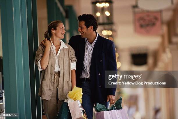 couple with shopping bags - mid adult couple stock pictures, royalty-free photos & images