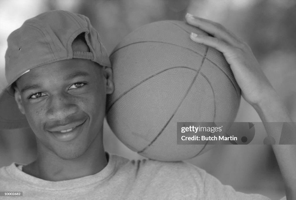 BLACK TEENAGE MALE WITH BASKETBALL IN BLACK AND WHITE