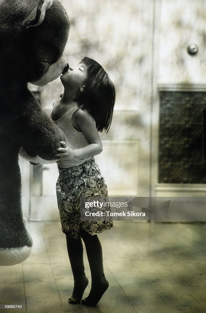 ASIAN GIRL KISSING BIG STUFFED BEAR IN BLACK AND WHITE