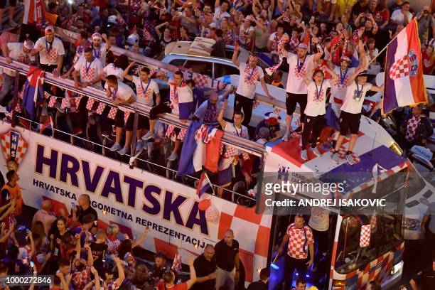 Croatian national football team players ride a bus as people gather for a "heroes' welcome" in tribute to their national team, after reaching the...