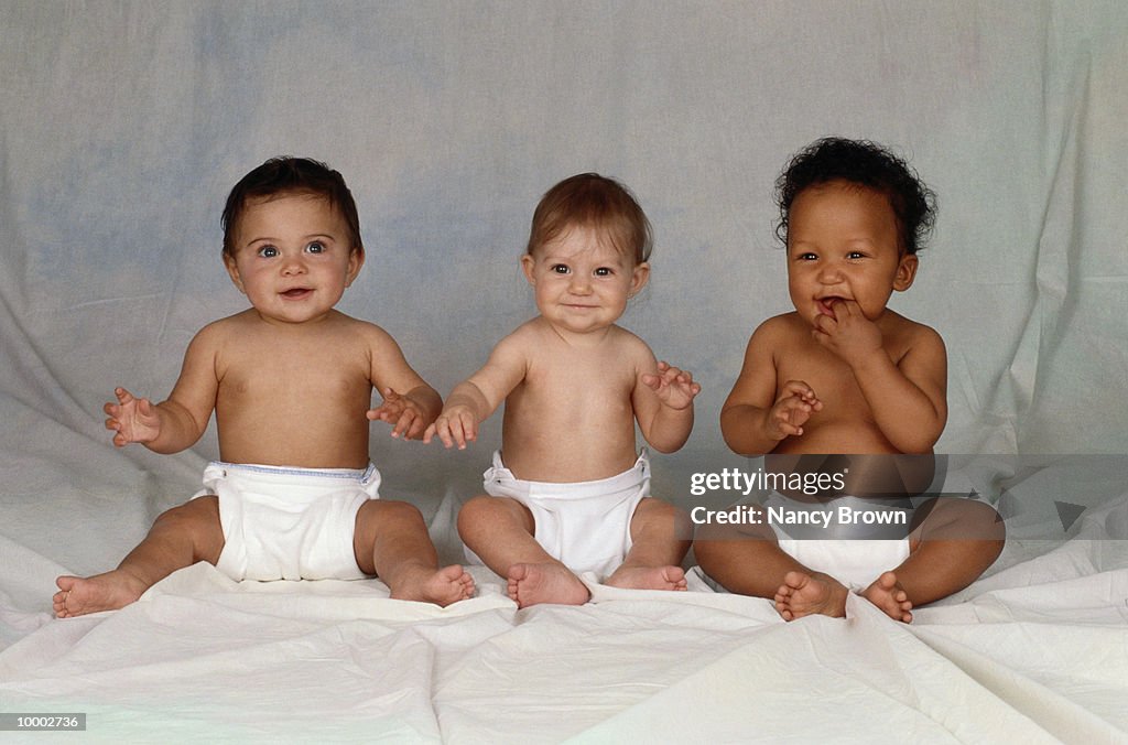 MULTI-ETHNIC BABIES SITTING IN DIAPERS