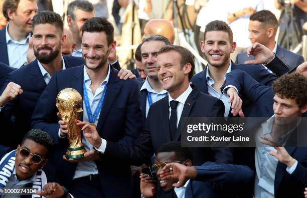 French President Emmanuel Macron pose with Olivier Giroud, Hugo Lloris, Paul Pogba, Lucas Hernandez and Benjamin Pavard and the World Cup trophy as...