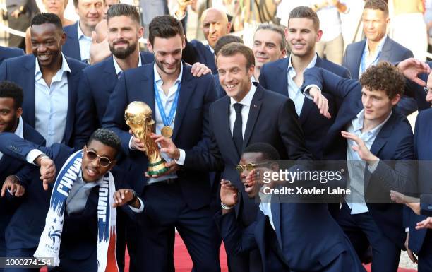 French President Emmanuel Macron pose with Olivier Giroud, Hugo Lloris, Paul Pogba, Lucas Hernandez and Benjamin Pavard and the World Cup trophy as...