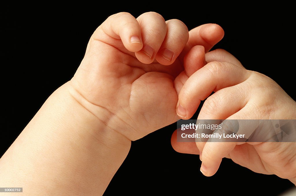 BABY'S INTERLOCKED HANDS IN DETAIL
