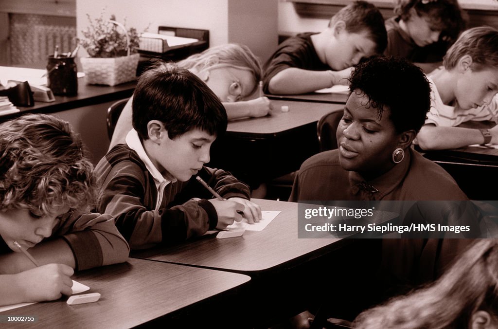 BLACK TEACHER WITH STUDENTS IN CLASS IN BLACK AND WHITE