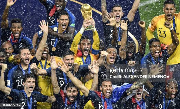 France's goalkeeper Hugo Lloris holds the trophy as he celebrates with teammates during the trophy ceremony at the end of the Russia 2018 World Cup...