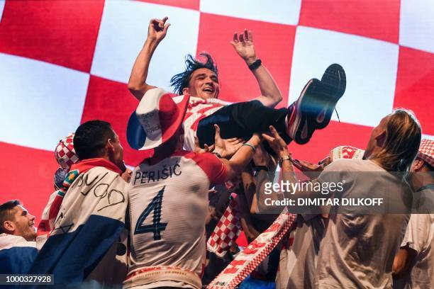 Croatian coach Zlatko Dalic is tossed by his players during a welcoming ceremony at the Bana Jelacica Square in Zagreb on July 16 after reaching the...