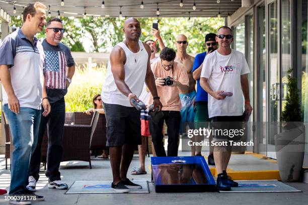 Chris Rose and Kevin Millar watch Torii Hunter play cornhole at the Oakley Pool Party Featuring Deep Eddy Vodka at Capitol Skyline Hotel Pool on July...