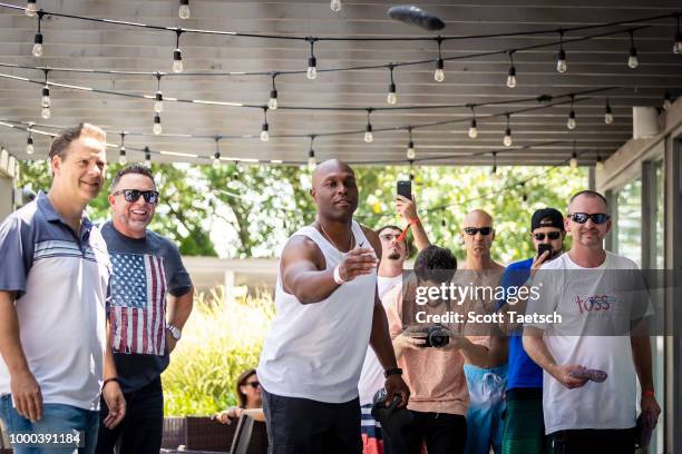 Chris Rose and Kevin Millar watch Torii Hunter play cornhole at the Oakley Pool Party Featuring Deep Eddy Vodka at Capitol Skyline Hotel Pool on July...