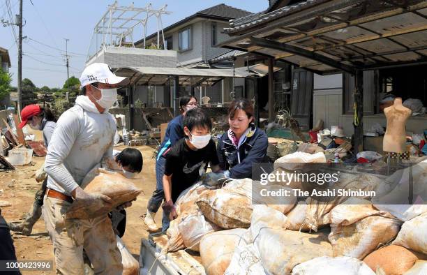 Vounteer workers remove debris on July 16, 2018 in Kurashiki, Okayama, Japan. More than 100 people were treated for heatstroke as scorching summer...