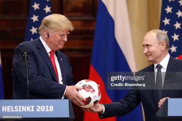 President Donald Trump, left, receives a soccer ball from Vladimir Putin, Russia's president, during a news conference in Helsinki, Finland, on...