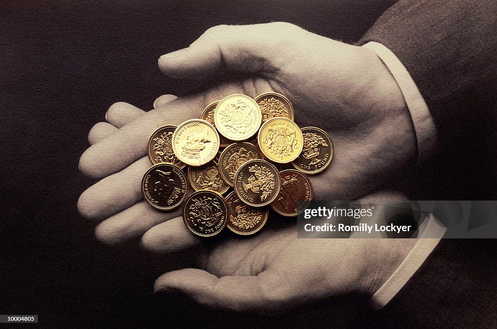 HANDS HOLDING UK ONE POUND COINS