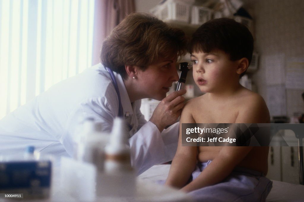 FEMALE DOCTOR EXAMINING BOY'S EARS