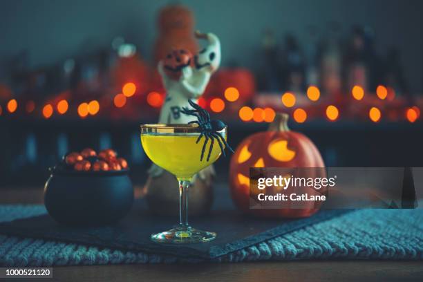 halloween-tijd. levendige gekleurde dranken met ketel van snoep - cocktail party stockfoto's en -beelden