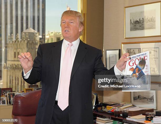 Donald Trump holds up a copy of GOLF Magazine in which he's featured during Miss USA 2010 Rima Fakih's visit to Trump Tower on May 20, 2010 in New...