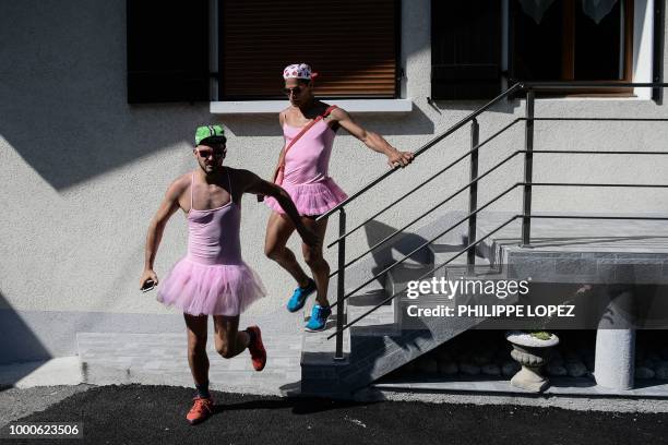 Spectators dressed in dancing tutu rush to watch the riders during the tenth stage of the 105th edition of the Tour de France cycling race between...