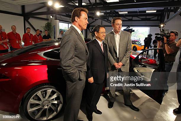 California governor Arnold Schwarzenegger, Toyota CEO Akio Toyoda and Tesla Motors CEO Elon Musk pose in front of a Tesla Model S before a news...