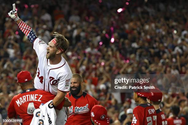 Bryce Harper of the Washington Nationals and National League celebrates with his manager Dave Martinez after winning the T-Mobile Home Run Derby at...