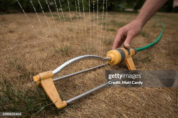 In this photo illustration a man adjusts a hosepipe sprinkler in a garden of a house in the village of Priston on July 17, 2018 near Bath, England....