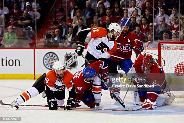 Mike Richards and Simon Gagne of the Philadelphia Flyers fight for the puck against Josh Gorges, Brian Gionta and Jaroslav Halak of the Montreal...