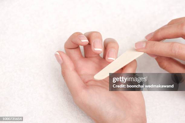 woman hands in a nail salon receiving a manicure. - artificial nails stock pictures, royalty-free photos & images