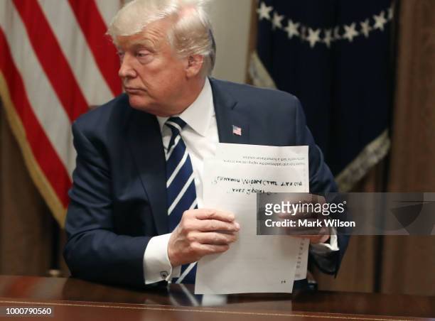 President Donald Trump holds his notes as he talks about his meeting with Russian President Vladimir Putin, during a meeting with House Republicans...